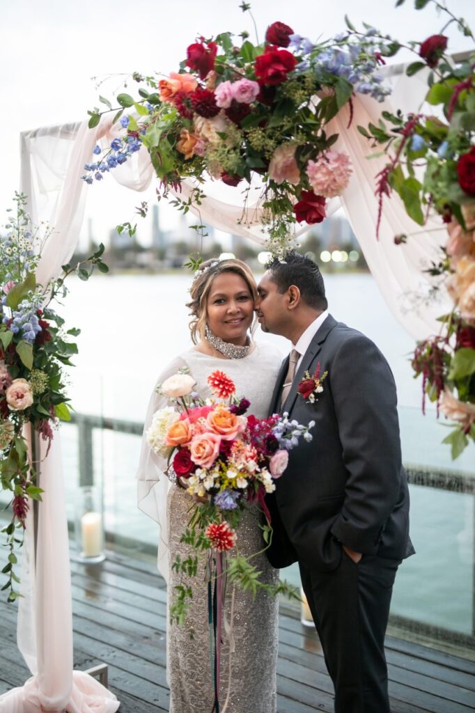 bride and groom with wedding arch